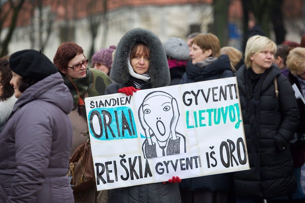 Mokytojų streikas, 2018 m. Mokytoja laiko plakatą „Šiandien oriai gyventi Lietuvoje reiškia gyventi iš oro“