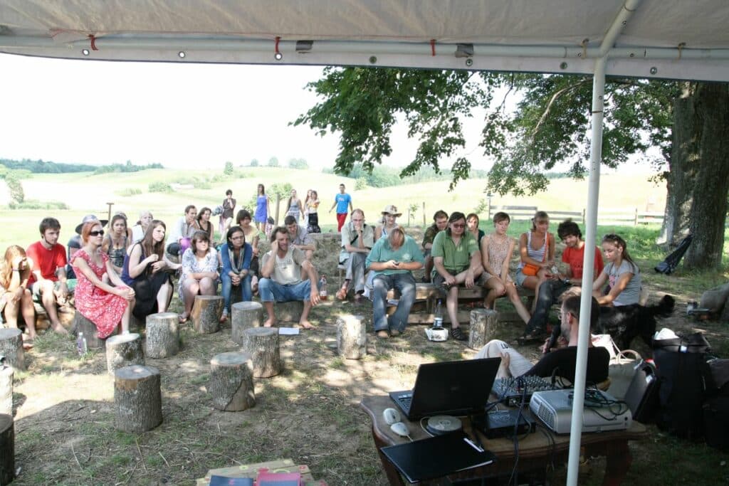 Žmonės LUNI stovykloje klauso paskaitos